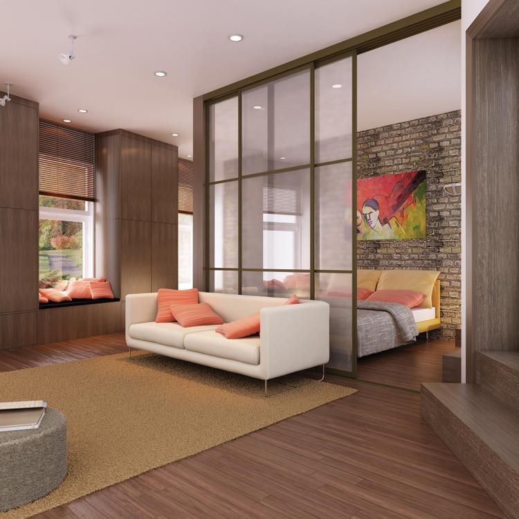 Moderner Glas-Raumteiler mit Metallrahmen trennt Wohnzimmer und Schlafzimmer in einem Loft mit Holzboden und Ziegelwand.