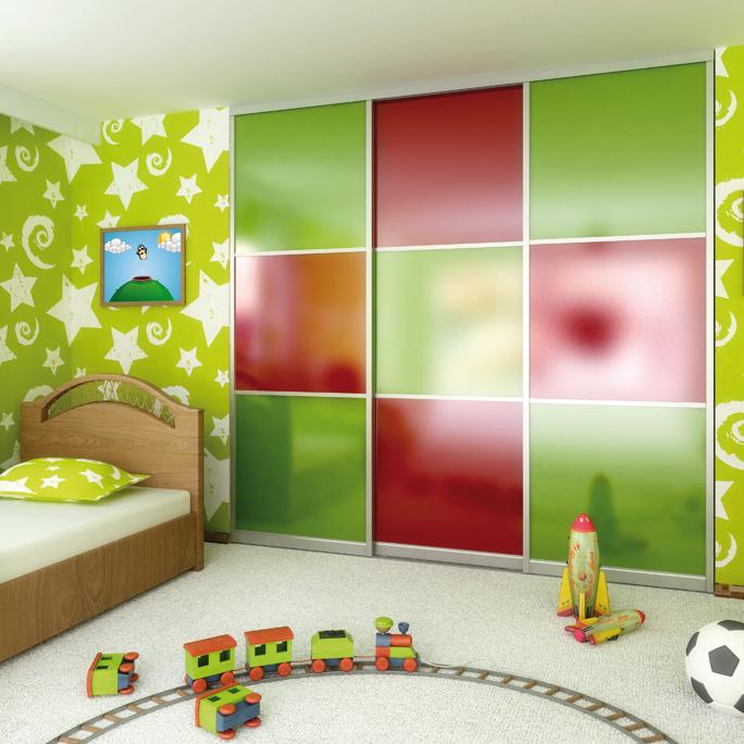 Farbiger Schiebetürenschrank mit roten und grünen Glasfronten in einem Kinderzimmer mit grün-weißer Sternentapete und Holzbetten.