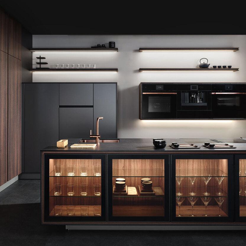Küche nach Maß mit dunklen Holzelementen, Glasvitrine und modernen Einbaugeräten.