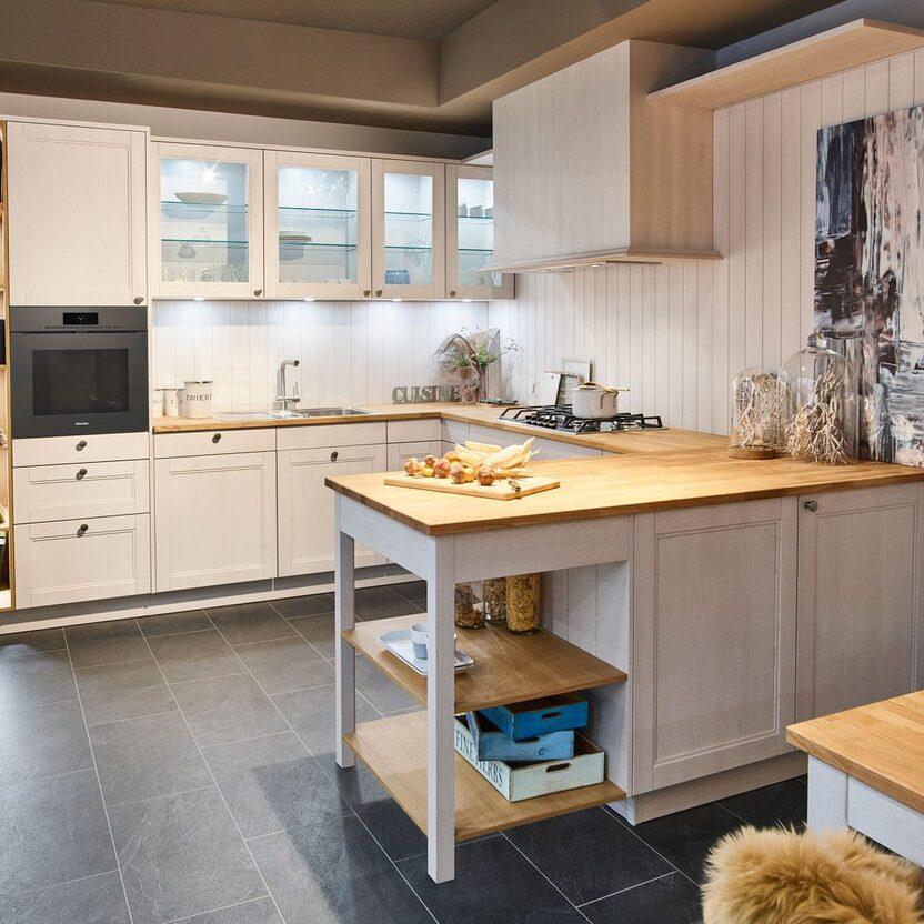 Küche nach Maß in hellem Holz mit Regal, Glasvitrinen und gemütlicher Eckbank.