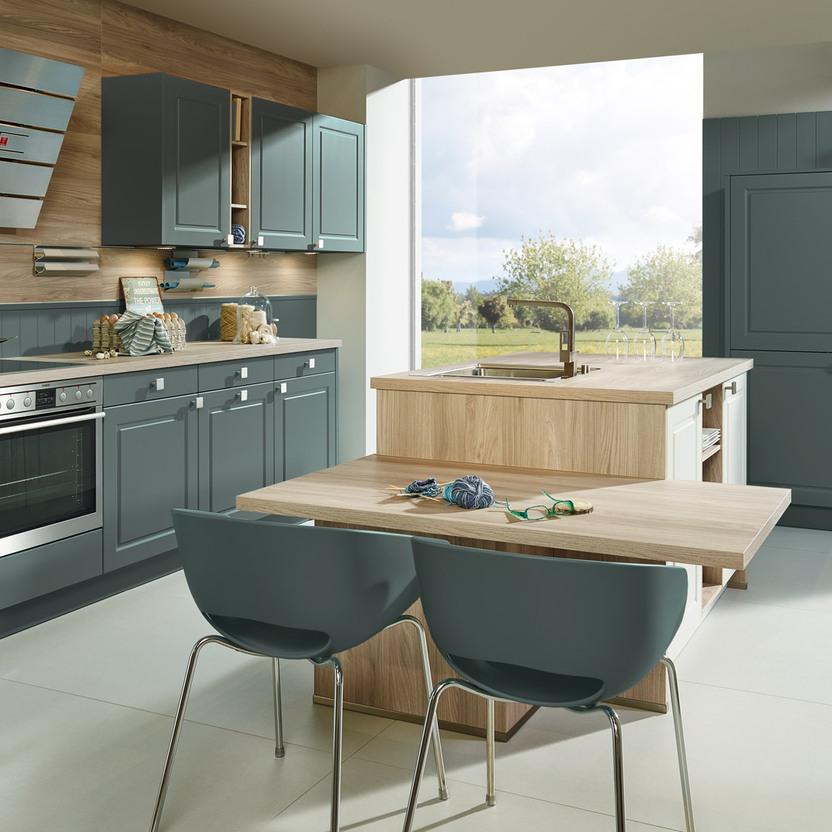 Küche nach Maß mit grün-matten Fronten, Holzdekor und Essbereich mit Fensterblick.