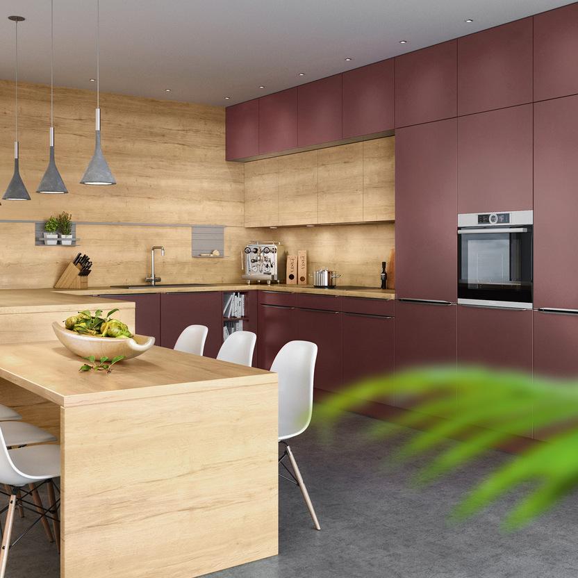 Küche nach Maß mit matten Fronten in Rot, Holzrückwand und integriertem Esstisch.