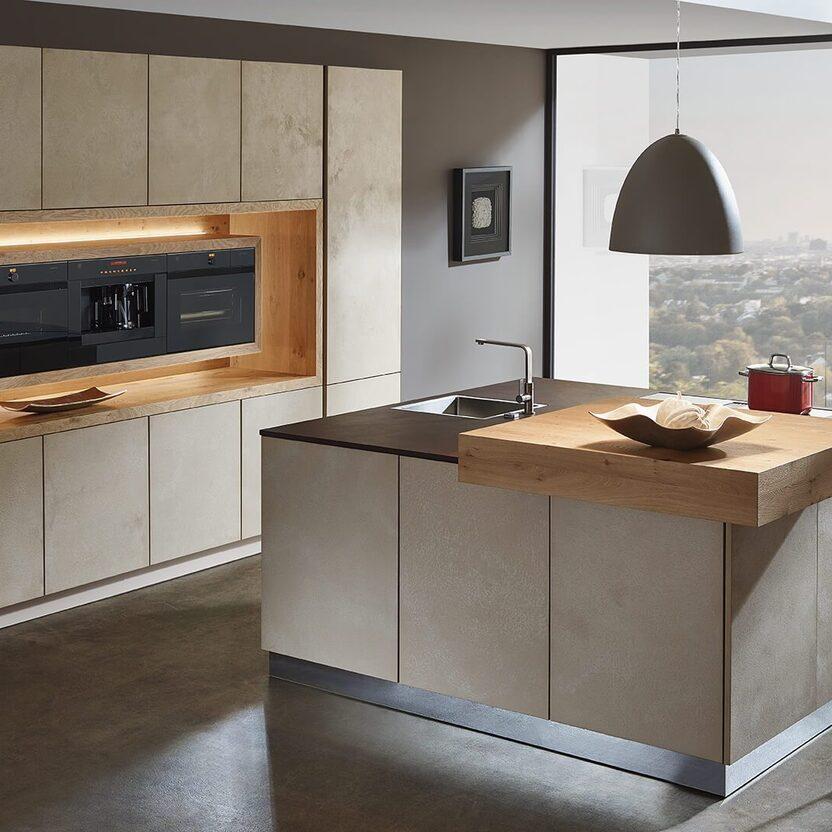 Küche nach Maß mit Steinfronten, Holzakzenten und modernem Ausblick ins Tal.