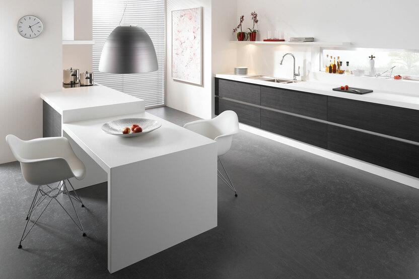 Impression einer Küchengestaltung mit Essplatz für Zwei Impression einer einzeiligen Küchengestaltung in schwarz-weiß mit Esstisch für Zwei