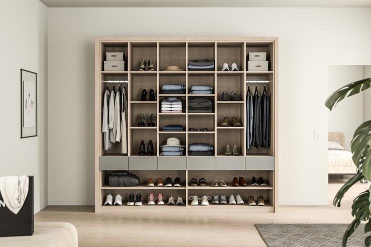Ein auf Maß gefertigter, strukturierter Kleiderschrank, der Kleidung und Schuhe übersichtlich präsentiert, mit Holzakzenten.