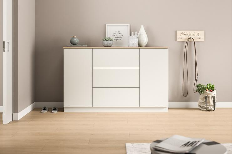 Schlichte Kommode nach Maß im modernen Eingangsbereich. Eine maßgefertigte, weiße Kommode mit klaren Linien bietet diskreten Stauraum und eine minimalistische Ästhetik im Eingangsbereich des Hauses.