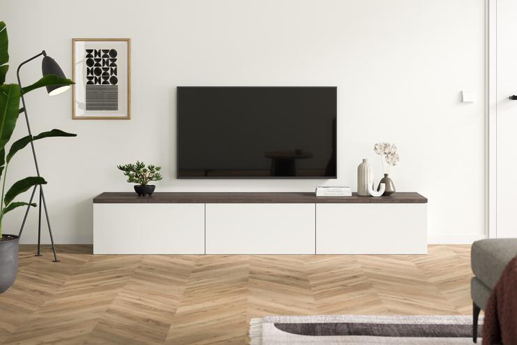 Maßgeschneiderte Kommode in schlichtem Design als TV-Unterschrank Zeitgenössische Kommode nach Maß mit weißen und dunklen Holzelementen im Wohnbereich dient als stilvoller Unterschrank für einen Flachbildfernseher.